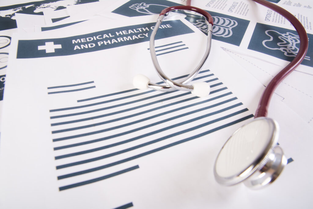 A stethoscope resting on medical documents representing Affordable Care Act plans and healthcare benefits in Massachusetts.