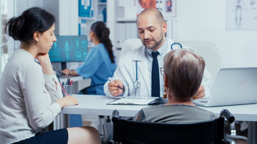 Health insurance non ACA consultation with a doctor, showing a patient in a wheelchair and a family member discussing coverage options at a medical clinic.
