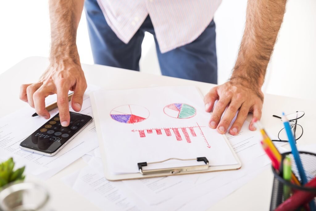 What is the ACA affordability percentage for 2025 calculation shown with charts, reports, and calculator on office desk